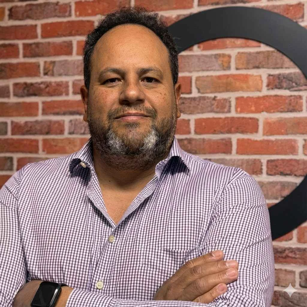 Deublis Santos, contador responsável técnico da ContConnect, de braços cruzados diante do símbolo da empresa